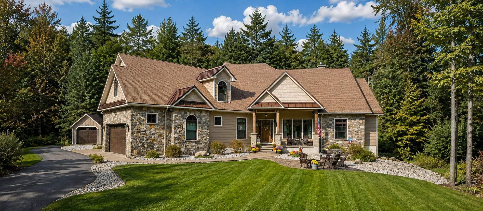 Stone and tan-sided ranch home with a hip roof and an attached garage