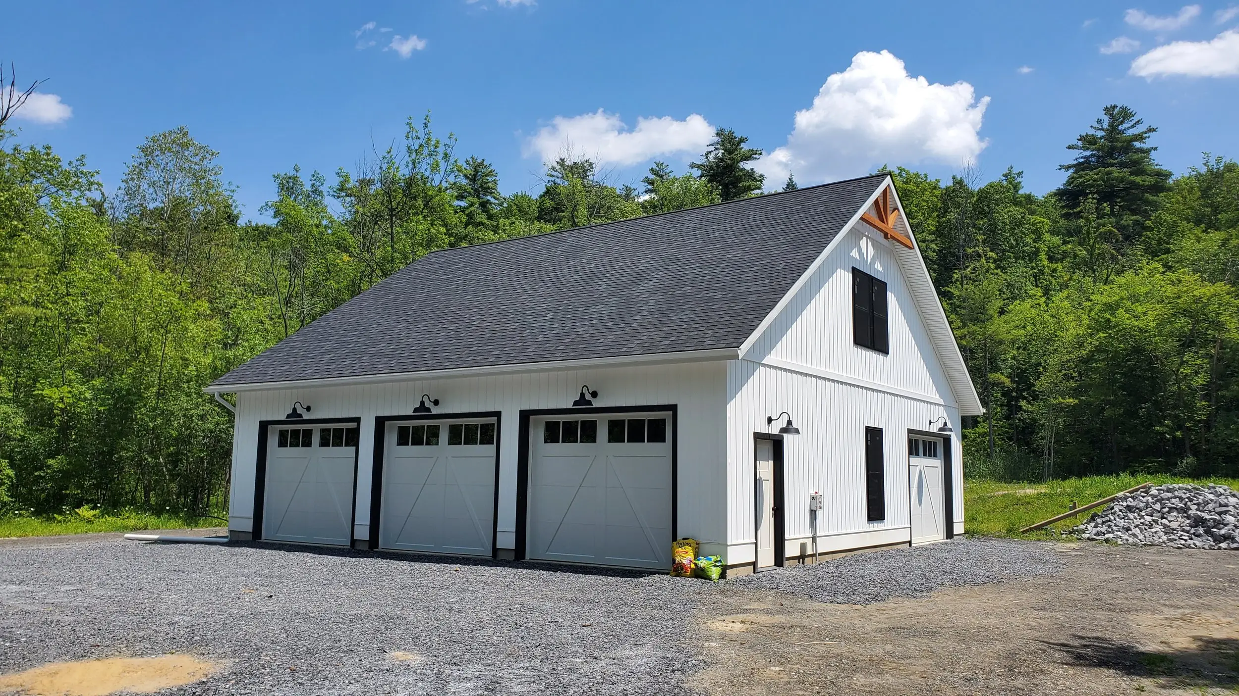 White three-car garage with black barn-style doors