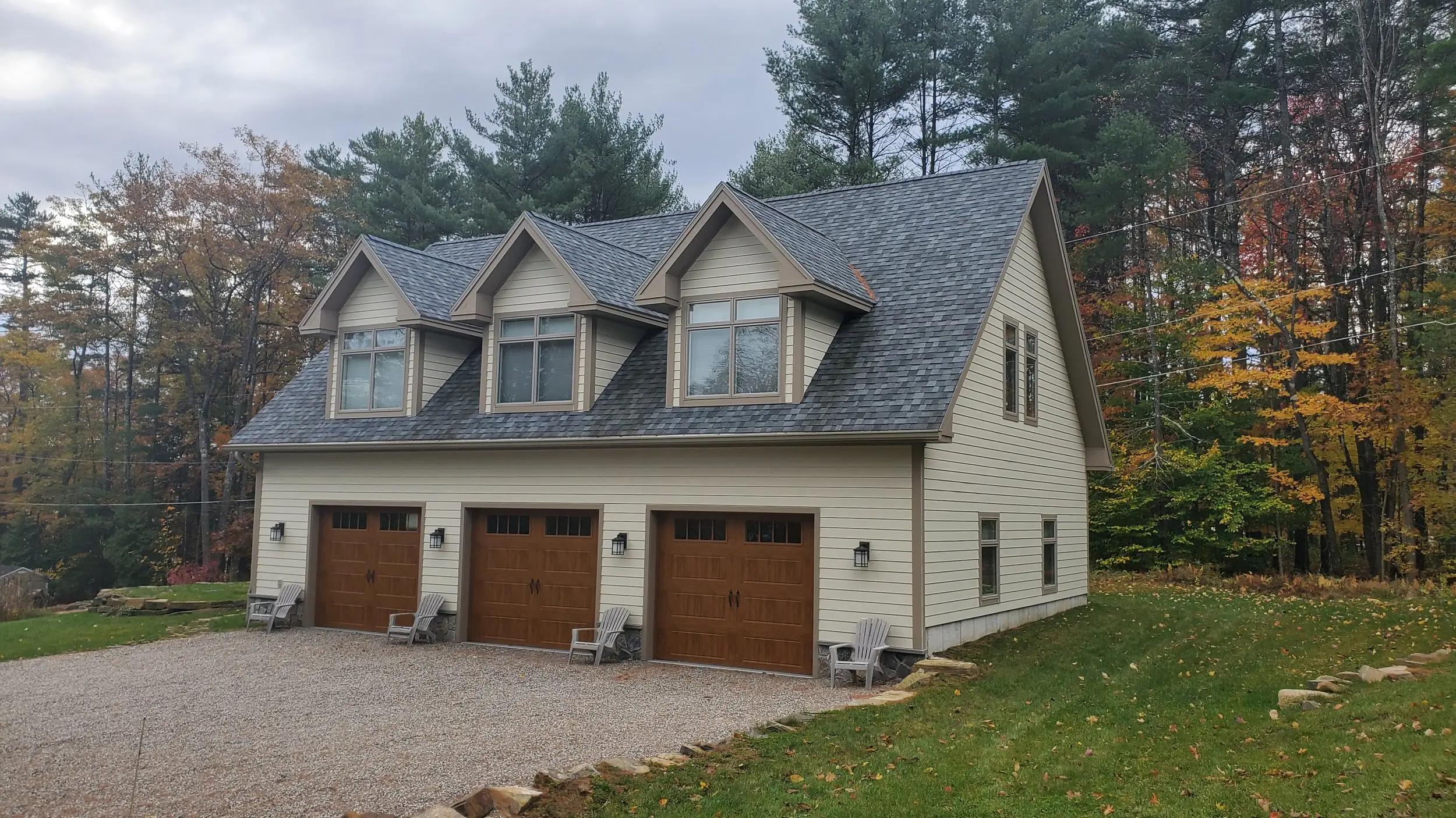 Cream three-car garage with three dormers above
