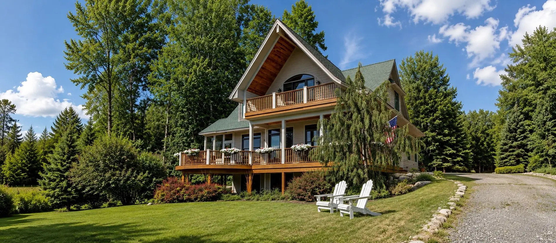 A-frame home with two levels of decks above a wooded lawn